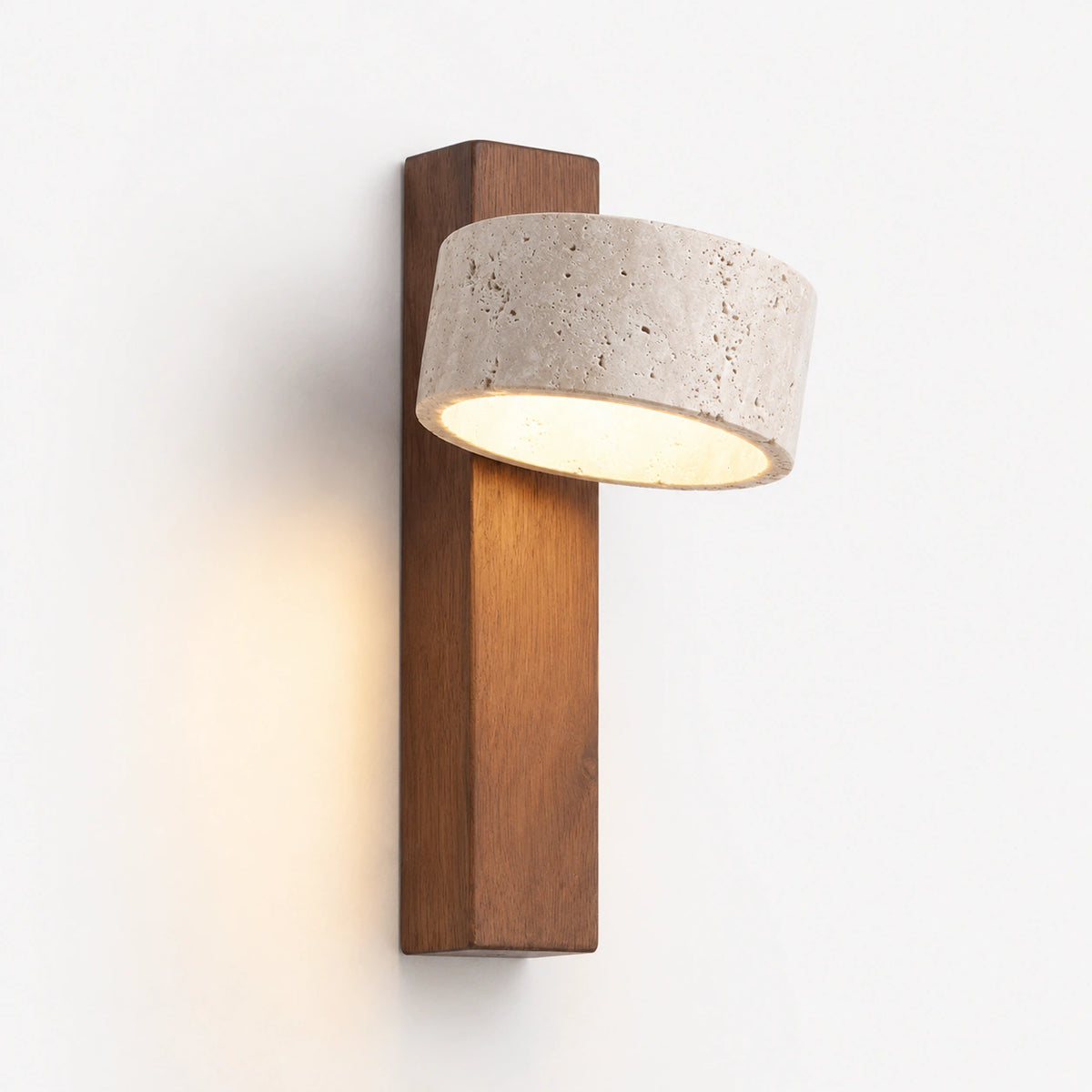 Cream travertine drum wall light crossing a tall walnut backplate