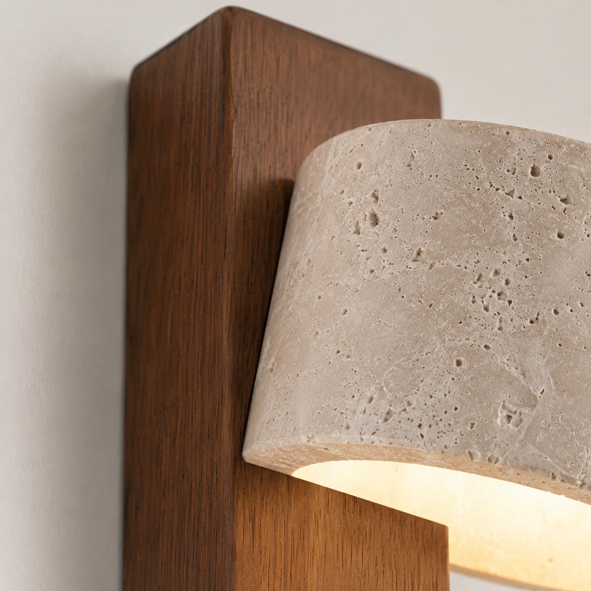 Close-up of the travertine drum meeting the walnut backplate on the Alnwick wall light