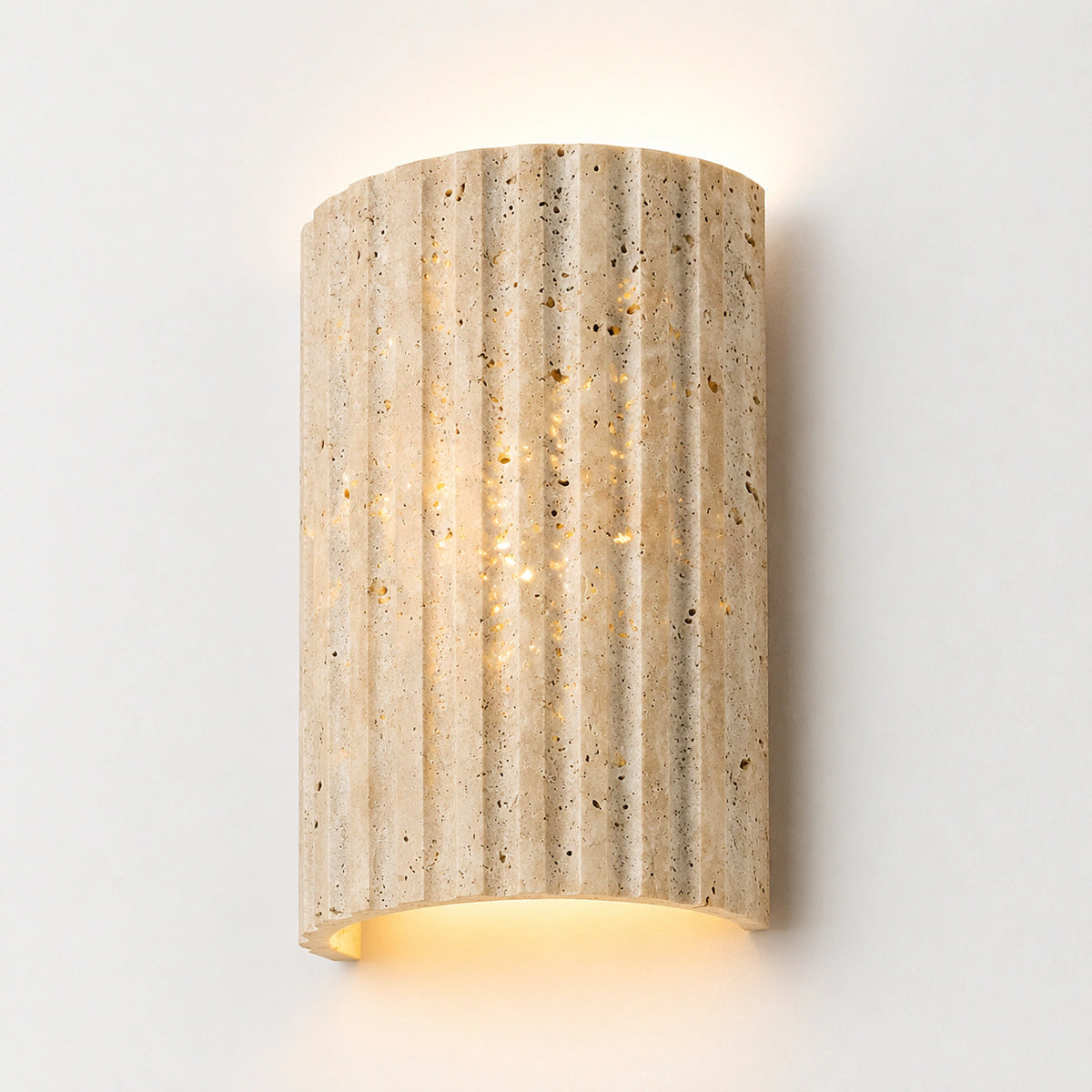 Fluted honey travertine wall light with carved vertical ribs, lit up and down