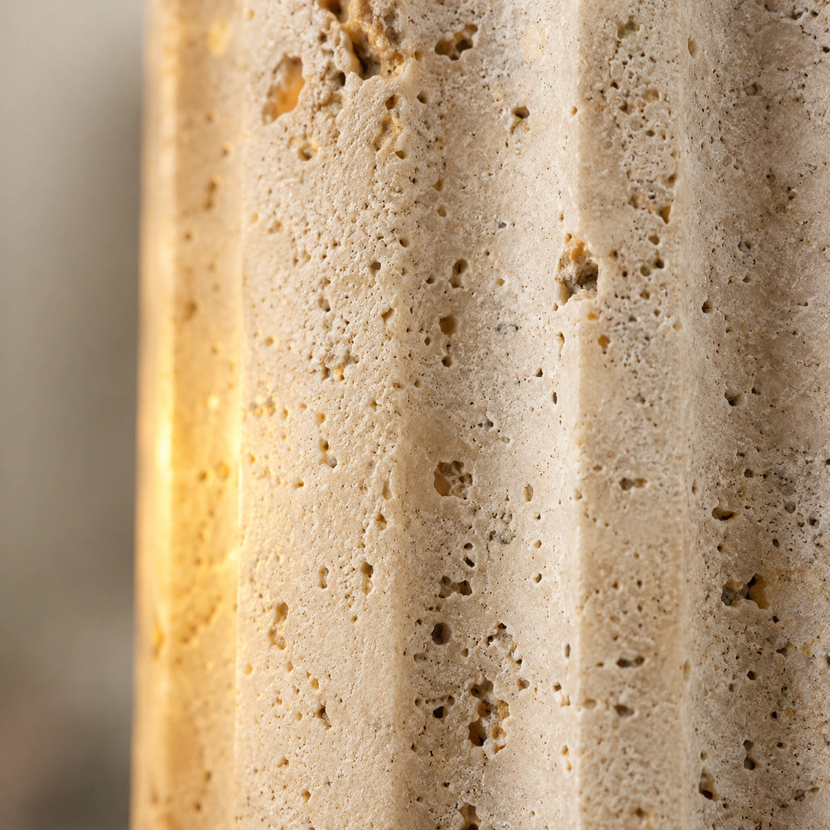 Close-up of the carved flutes crossing the travertine banding on the Ancaster wall light