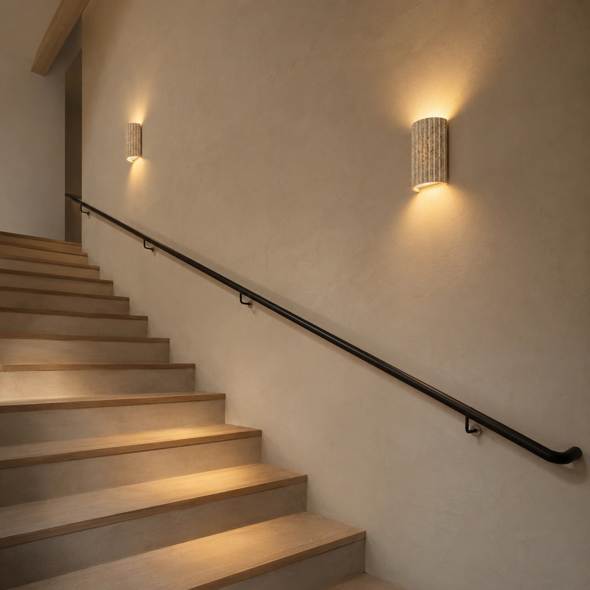 Ancaster fluted travertine wall light on a staircase wall