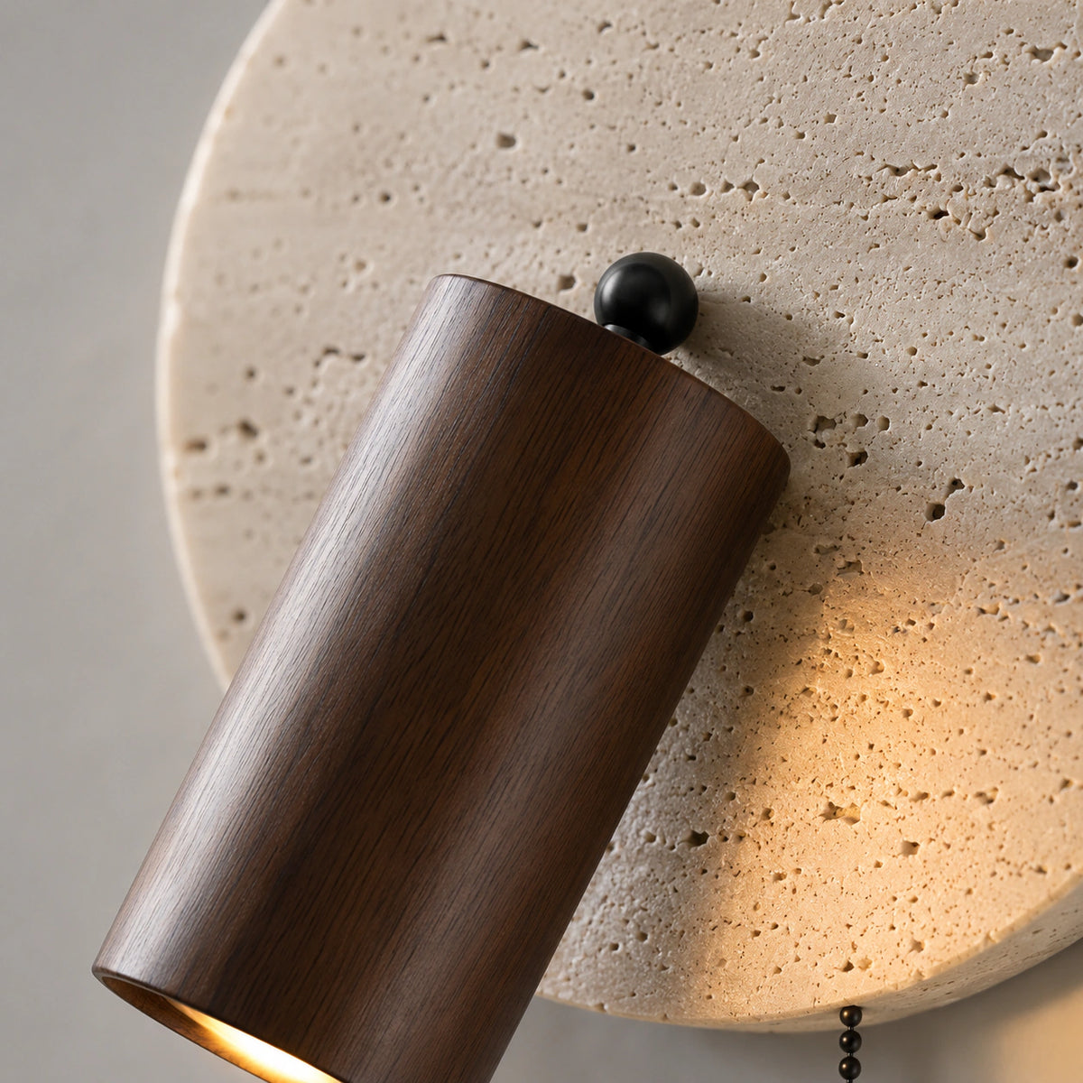 Close-up of the walnut spot and black cord on the Bramfield travertine wall light